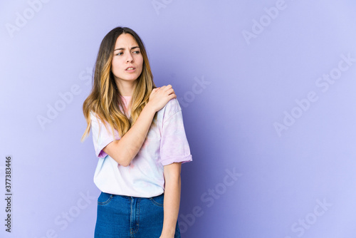 Young caucasian woman isolated on purple background having a shoulder pain.