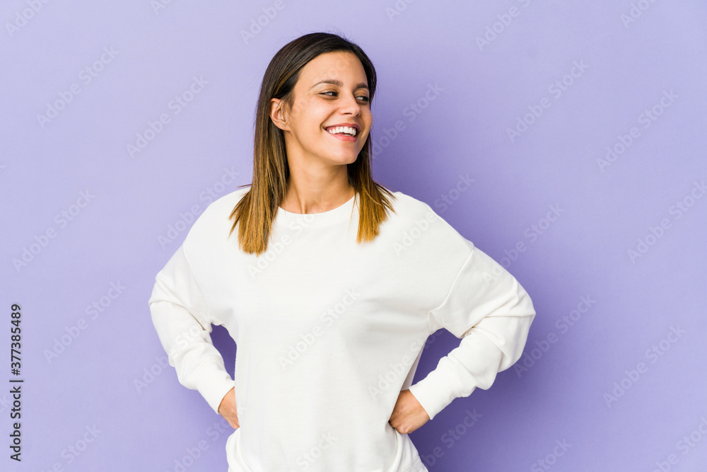 Young woman isolated on purple background dreaming of achieving goals and purposes