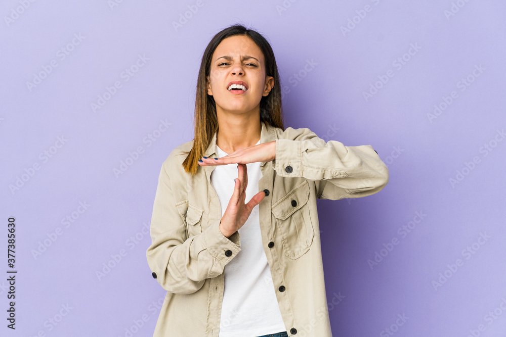 Young woman isolated on purple background showing a timeout gesture. Young woman isolated on purple background showing a timeout gesture.