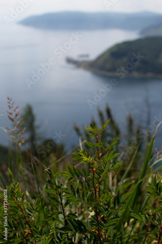 green grass, top view of rocks forest mountains near bay of blue lake baikal the mouth of angara river from chersky stone, port of baikal photo