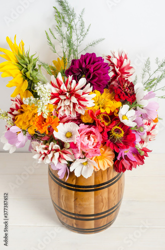 Colorful floral bouquet of garden flowers in a vase on a white background.