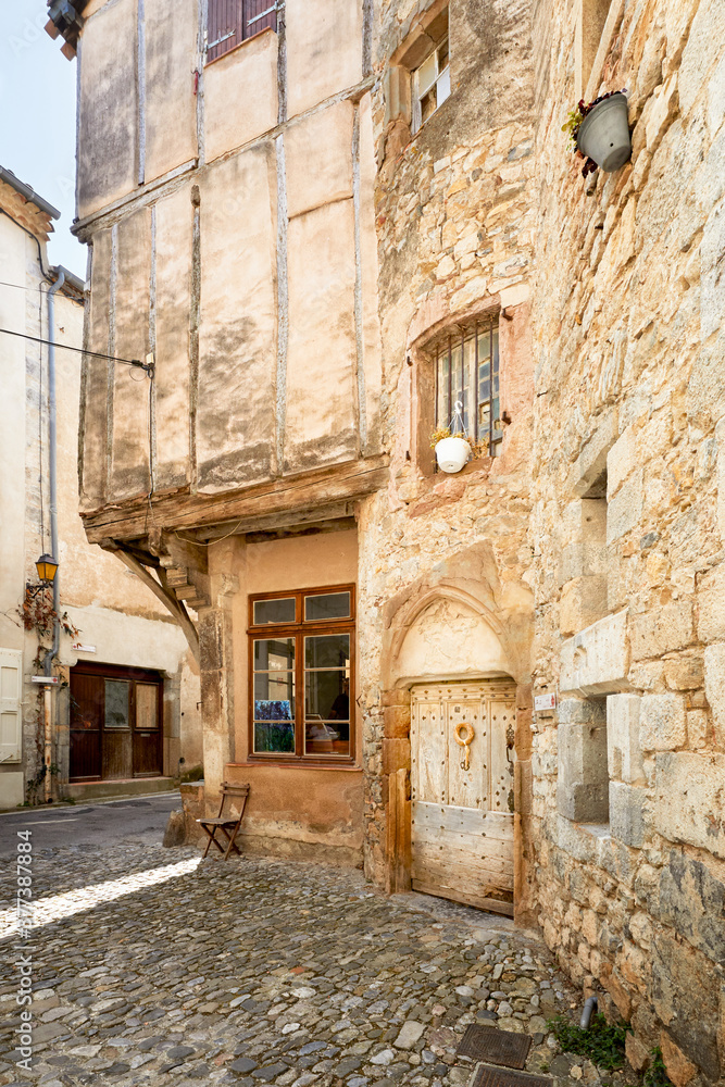 A 2020 view of a square with old houses in the village of Lagrasse, South of France.