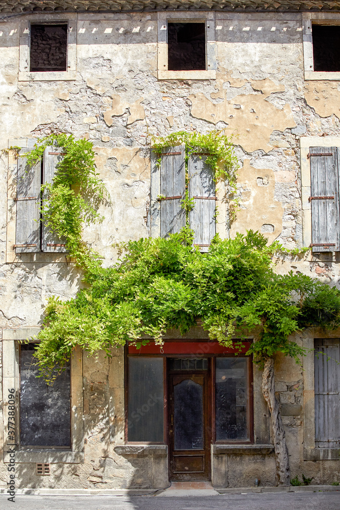A 2020 view of a medieval house with climbing ivy in Lagrasse, South of France. A 2020 view of a medieval house with climbing ivy in Lagrasse, South of France.