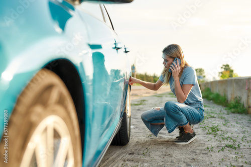 Φωτογραφία Attractive young woman looking sad, calling car service, assistance or tow truck