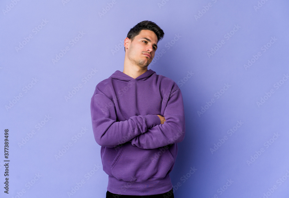 Obraz premium Young caucasian man isolated on purple background tired of a repetitive task.