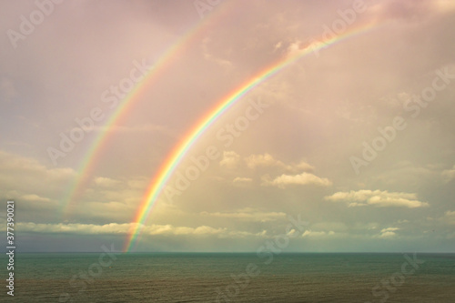 rainbow colorful above sea horizon at dawn