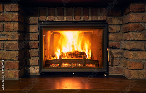 Photo fireplace and fire close view as object or background, brick wall