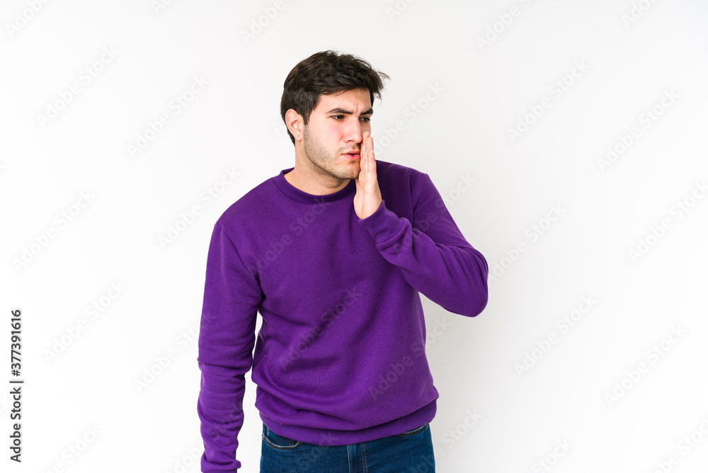 Young man isolated on white background is saying a secret hot braking news and looking aside Young man isolated on white background is saying a secret hot braking news and looking aside