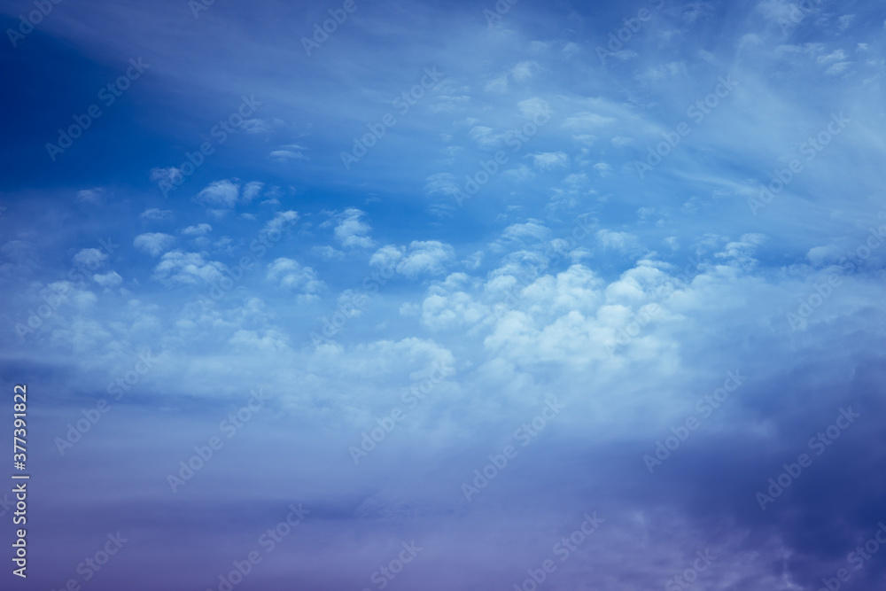 Beautiful blue sky background. Soft white clouds at sunset. Many pink, magenta and orange tones and patterns of clouds Beautiful blue sky background. Soft white clouds at sunset. Many pink, magenta and orange tones and patterns of clouds