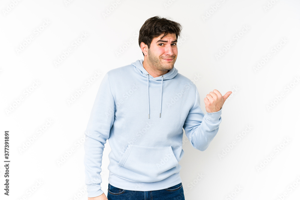 Young man isolated on white background shocked pointing with index fingers to a copy space. Young man isolated on white background shocked pointing with index fingers to a copy space.