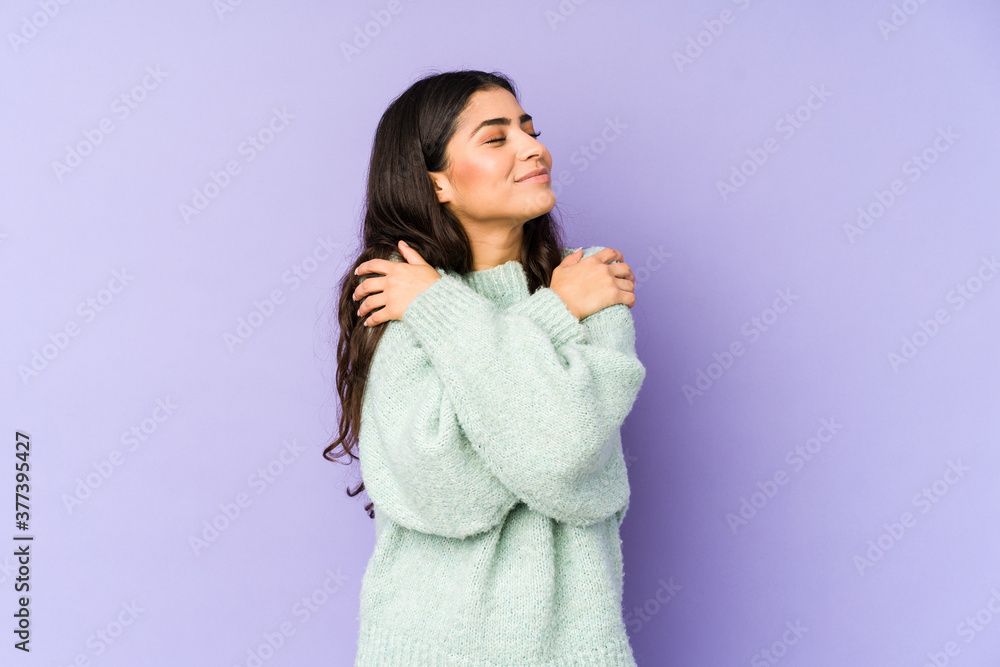 Young indian woman isolated on purple background hugs, smiling carefree and happy. Young indian woman isolated on purple background hugs, smiling carefree and happy.