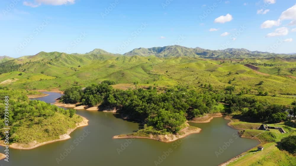 Aerial view of mountains and hills with rainforest and green grass under a blue sky with clouds on a Sunny summer day. Bohol, Philippines. Aerial view of mountains and hills with rainforest and green grass under a blue sky with clouds on a Sunny summer day. Bohol, Philippines.