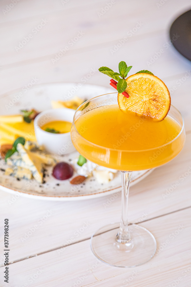 orange cocktail on a white background. decorated with a slice of dry orange orange cocktail on a white background. decorated with a slice of dry orange