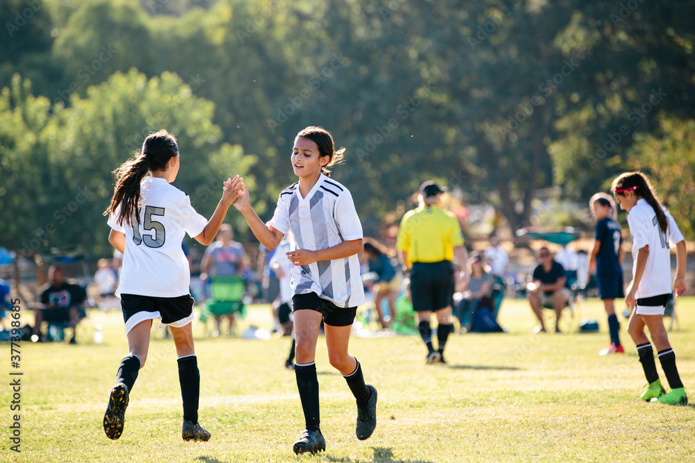 Soccer player girl gives her teammate a high five Soccer player girl gives her teammate a high five