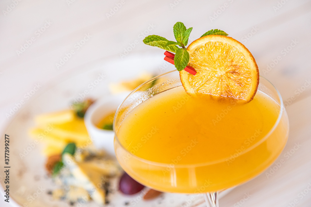 orange cocktail on a white background. decorated with a slice of dry orange orange cocktail on a white background. decorated with a slice of dry orange