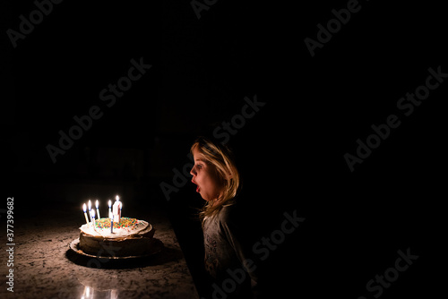 Little girl blowing out birthday cake candles