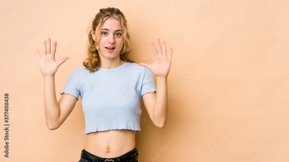 Young caucasian woman isolated on beige background receiving a pleasant surprise, excited and raising hands. Young caucasian woman isolated on beige background receiving a pleasant surprise, excited and raising hands.