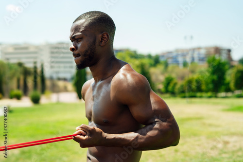 young athlete doing biceps exercise with rubber bands