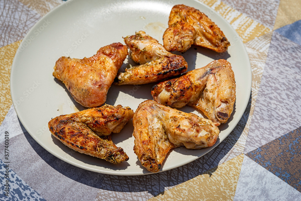 Spicy chicken wings grilling on a plate. Spicy chicken wings grilling on a plate.