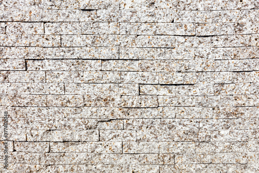 The wall is faced with gray granite stripes, close-up. The wall is faced with gray granite stripes, close-up.