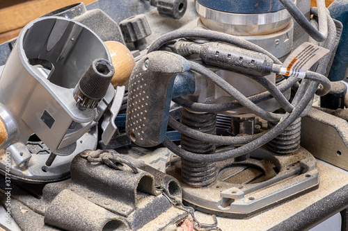 Electric router sitting on a workbench covered with sawdust © David Gales