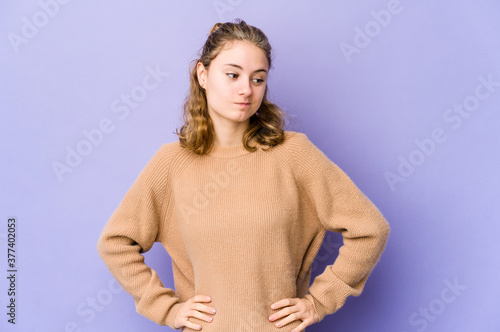 Young caucasian woman on purple background confused, feels doubtful and unsure.