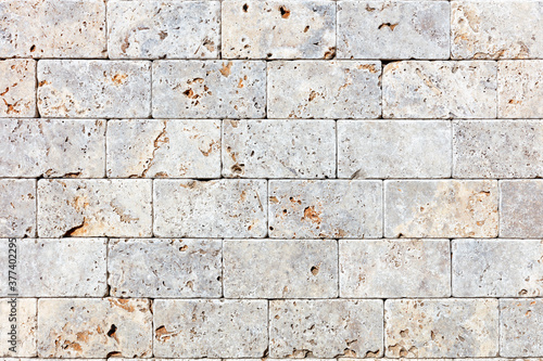 The wall is clad in hewn gray shell rock, texture and background.