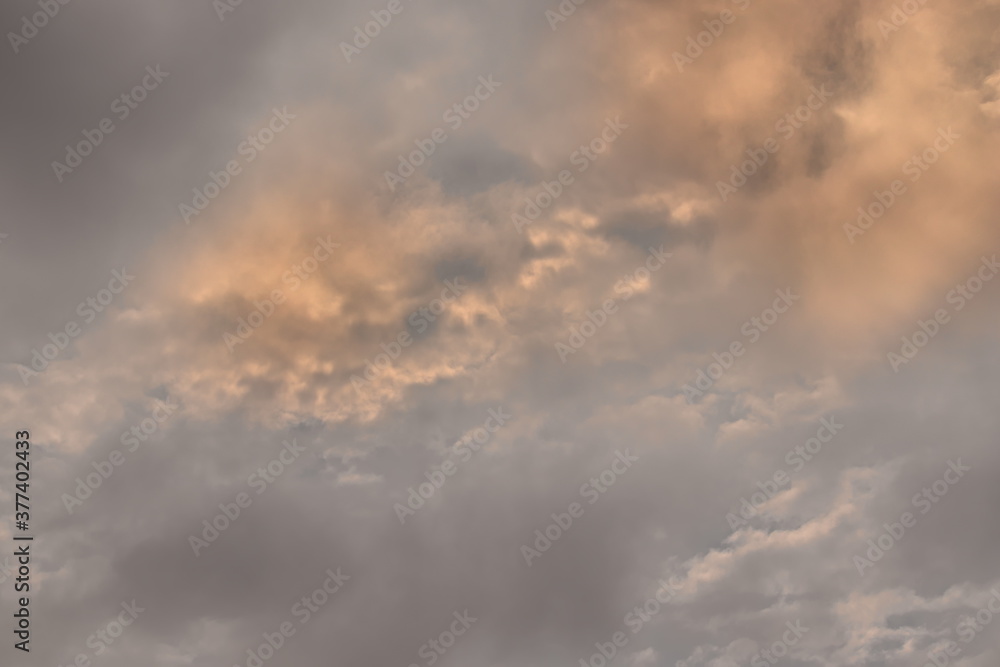 twilight sky with golden clouds surrounded by thin gray clouds.