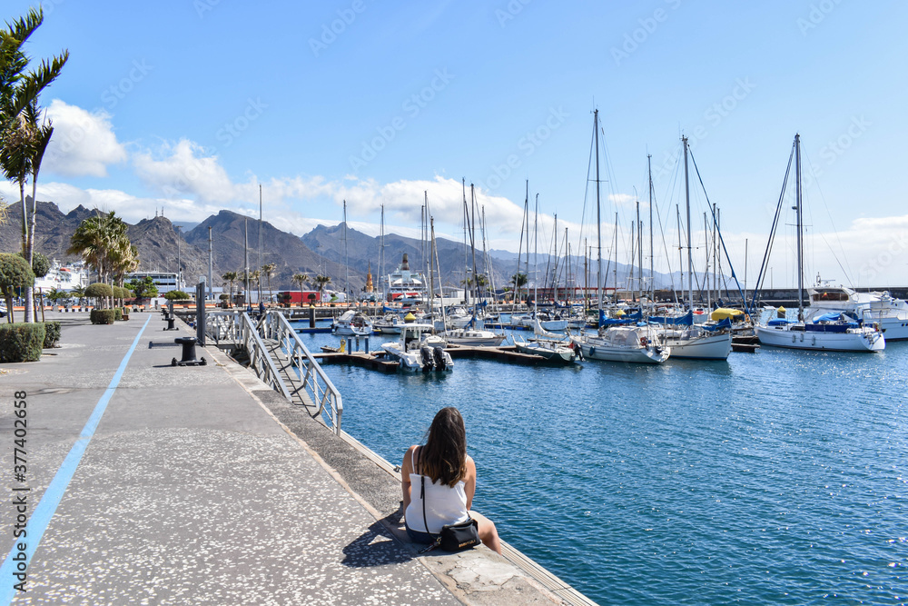 Girl sitting in a sea port