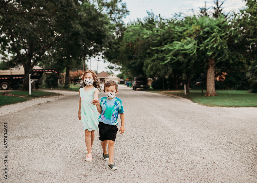 Young kids walking down street together wearing homemade masks Young kids walking down street together wearing homemade masks