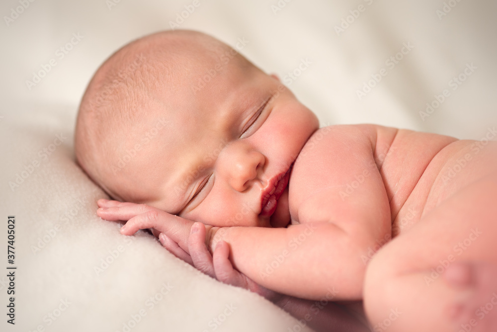 Front view of newborn baby sleeping with hands under his head Front view of newborn baby sleeping with hands under his head