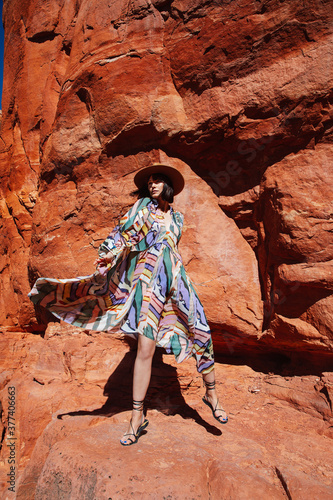 Young Stylish Cactus Cowgirl Stands on Red Rock