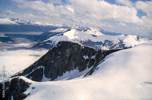 Photo of a glacier and ice fields amidst snow covered mountain peaks in Alaska © HJ