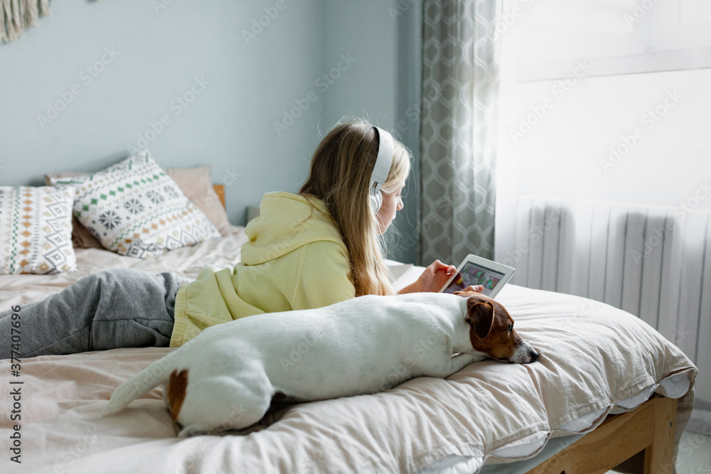 Child using tablet with dog on the bad Child using tablet with dog on the bad