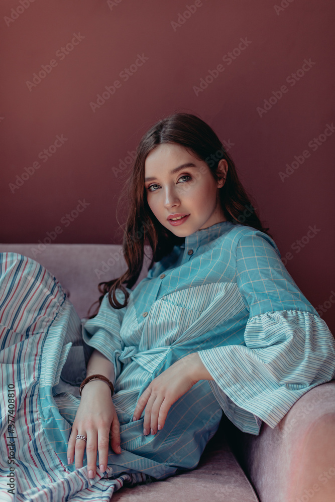 Portraits of a young girl on the sofa of a pink room. Portraits of a young girl on the sofa of a pink room.