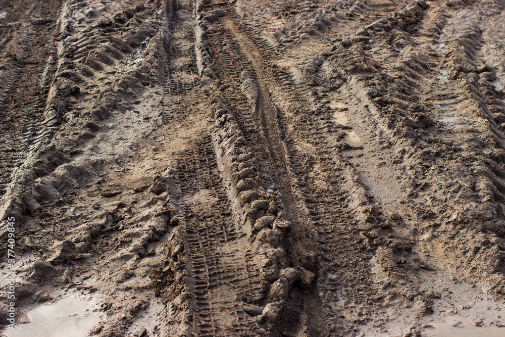 Dirty road with mud and puddles and truck wheel tracks after rain. Off-road. The background. Dirty road with mud and puddles and truck wheel tracks after rain. Off-road. The background.