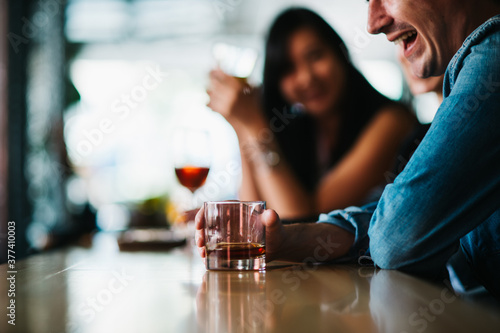 Anonymous people laughing and drinking at the bar photo