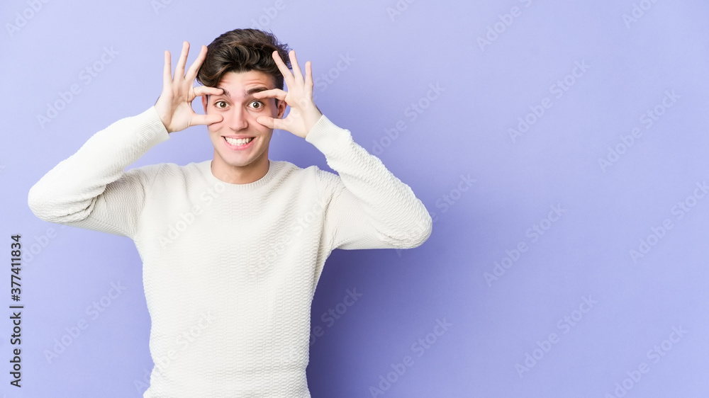 Young caucasian man isolated on purple background keeping eyes opened to find a success opportunity. Young caucasian man isolated on purple background keeping eyes opened to find a success opportunity.