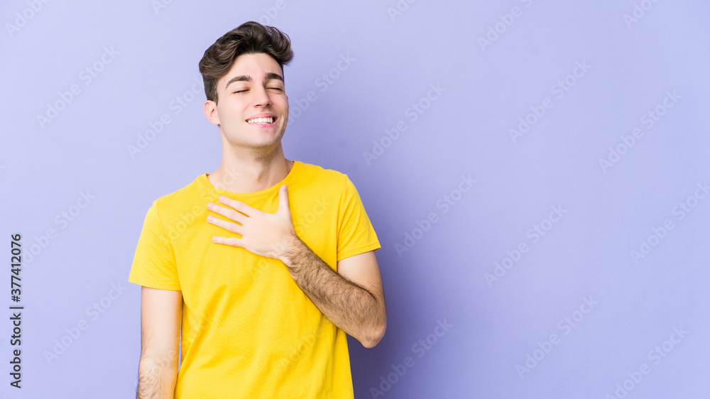 Young caucasian man isolated on purple background laughs out loudly keeping hand on chest. Young caucasian man isolated on purple background laughs out loudly keeping hand on chest.