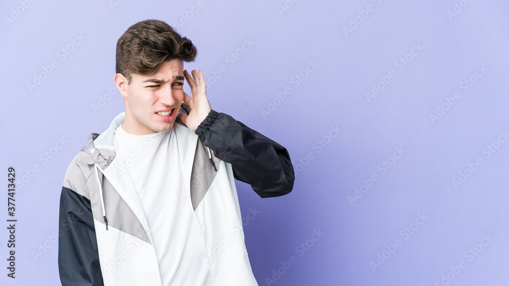 Young caucasian man isolated on purple background covering ears with hands. Young caucasian man isolated on purple background covering ears with hands.