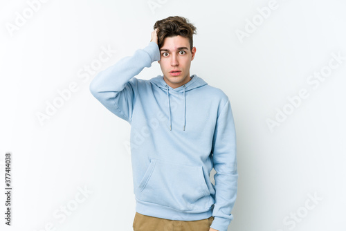 Young caucasian man isolated on white background being shocked, she has remembered important meeting.