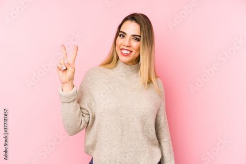 Middle age woman over isolated background showing number two with fingers.
