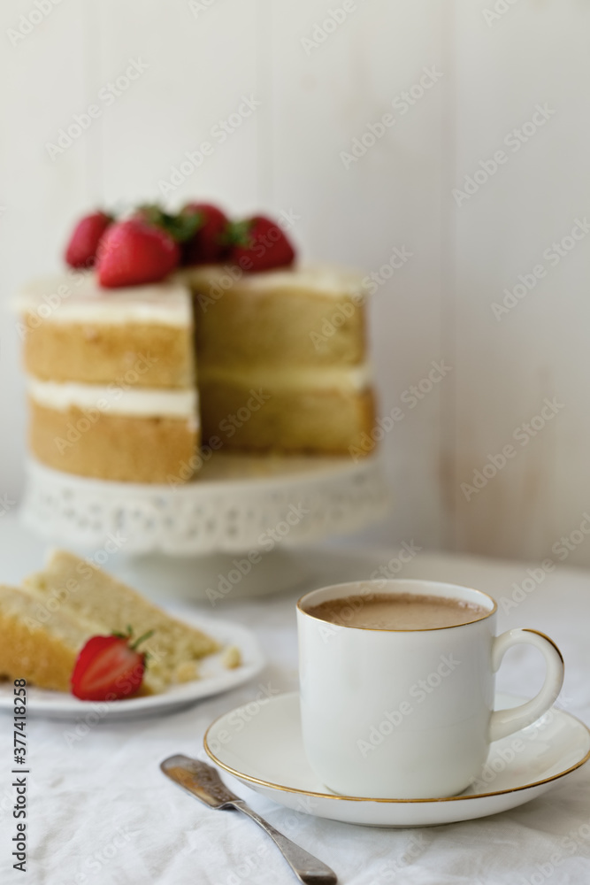 Strawberry cake with slice removed and cup of coffee Strawberry cake with slice removed and cup of coffee