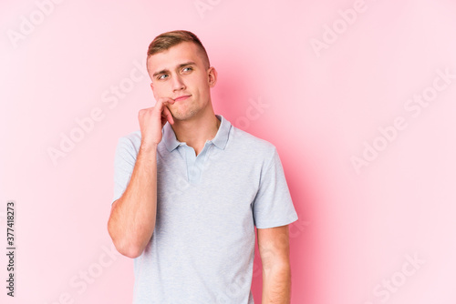 Young caucasian man isolated looking sideways with doubtful and skeptical expression.