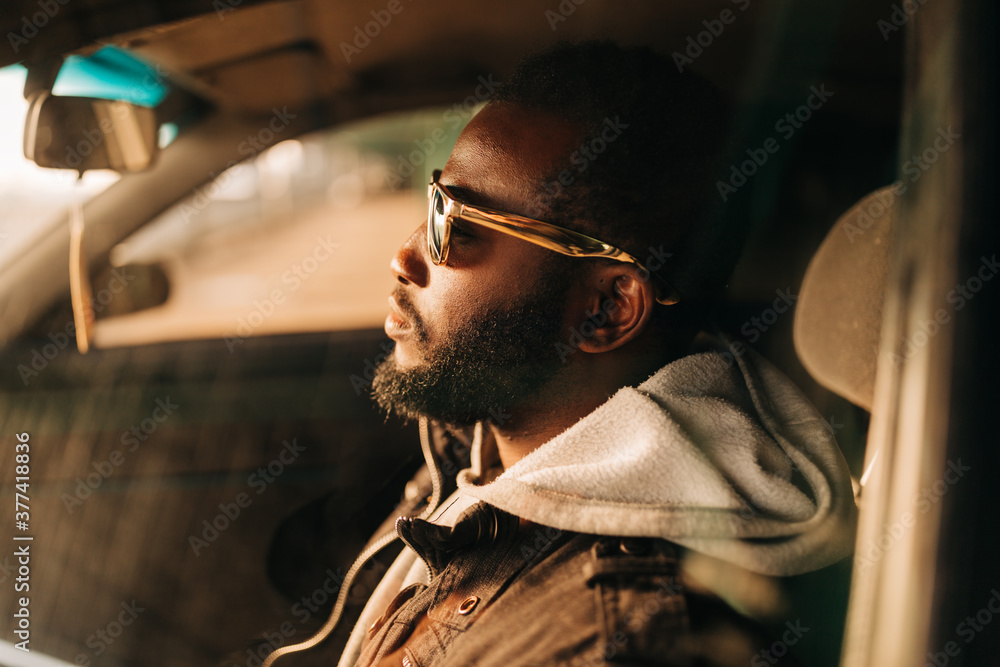 © Alexey Klementiev/Stocksy - young african american man in the car