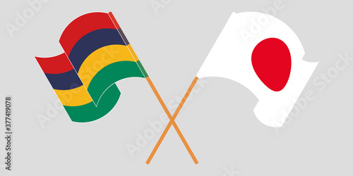 Crossed and waving flags of Mauritius and Japan