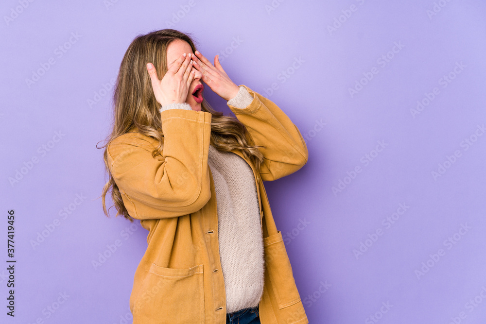 Young caucasian woman isolated on purple background afraid covering eyes with hands. Young caucasian woman isolated on purple background afraid covering eyes with hands.