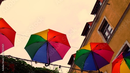 Umbrellas in rainbow colors above the street.