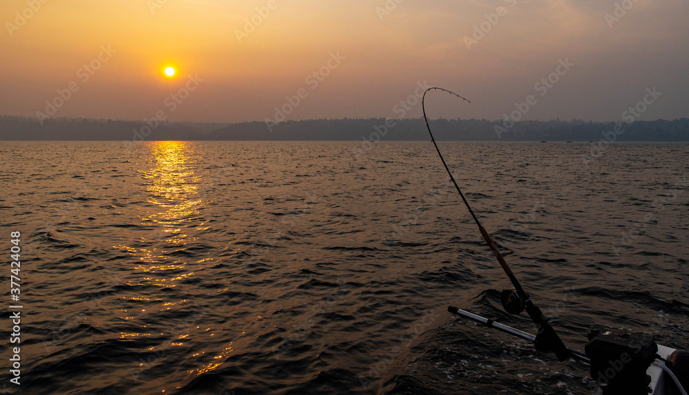 Fishing pole in the puget sound with a smoke filled sky and the rising sun over the water Fishing pole in the puget sound with a smoke filled sky and the rising sun over the water