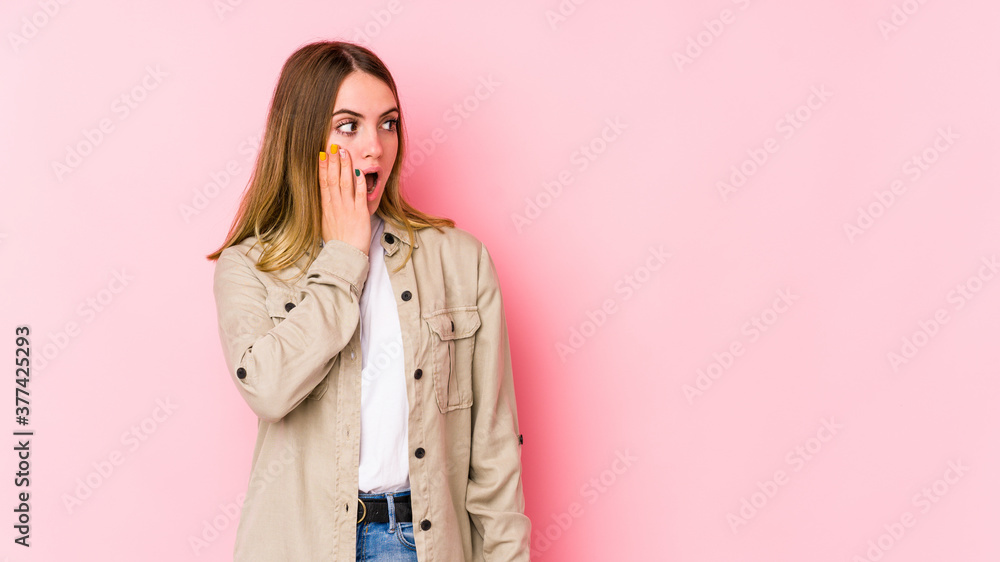 Young caucasian woman isolated on pink background being shocked because of something she has seen. Young caucasian woman isolated on pink background being shocked because of something she has seen.